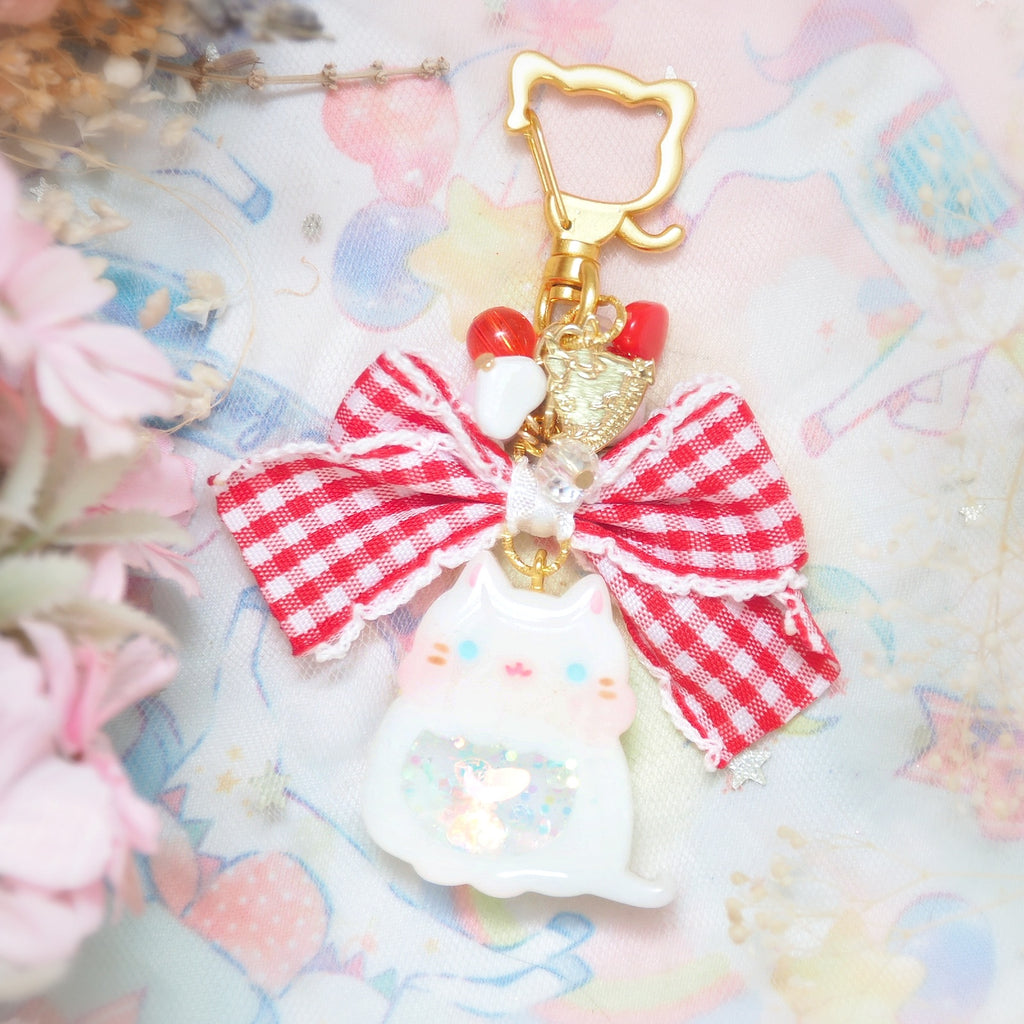 White cat with frilly checkered ribbon