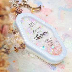 Manoir de la Lumiere Charm (White background, lavender frame)