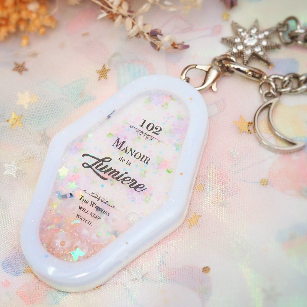 Manoir de la Lumiere Charm (White background, lavender frame)
