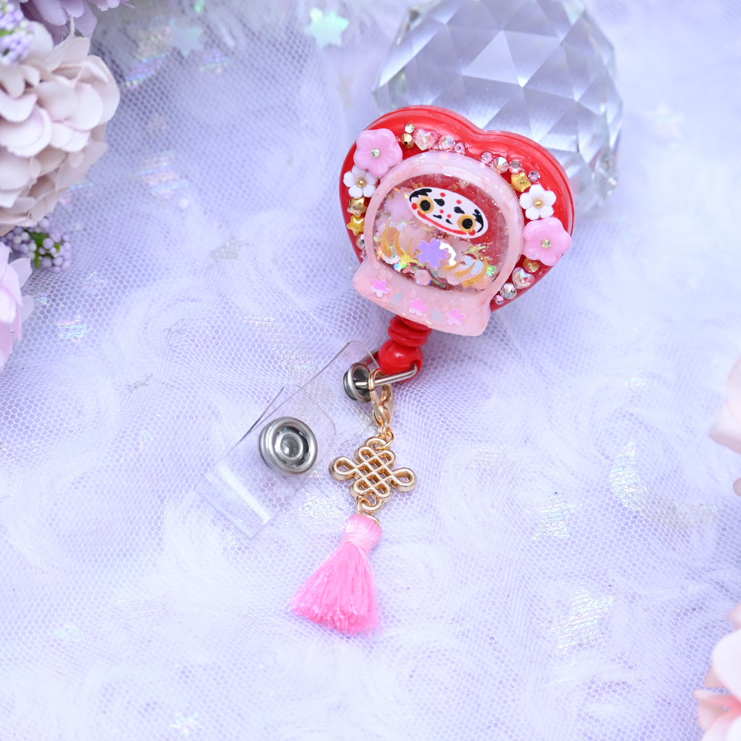 Tiny Pink Daruma badge reel